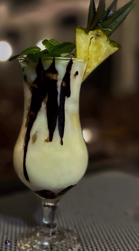 Drink cremoso decorado com abacaxi e hortelã